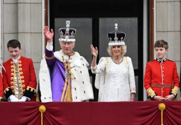 Charles acena para multidão na sacada do Palácio de Buckingham; sem Harry